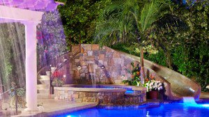 free form pool with custom waterslide into fiber optic pool